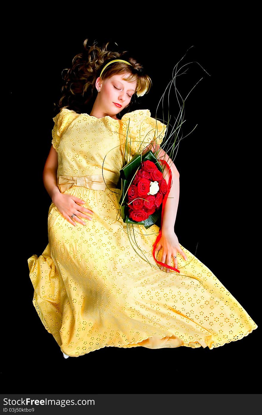 Portrait of a beautiful young bride showing her wedding bouquet of red and white roses on black background, studio shot. Portrait of a beautiful young bride showing her wedding bouquet of red and white roses on black background, studio shot