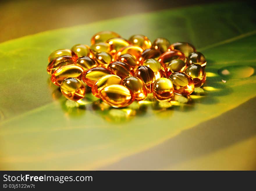 Yellow pills on green background, photography