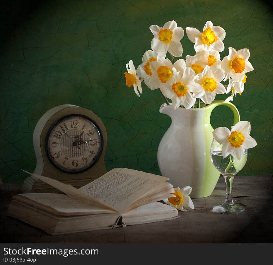 A bouquet of narcissuses, alongside clock and book