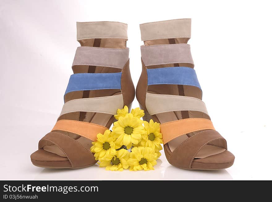 Two women shoes composition with yellow flowers