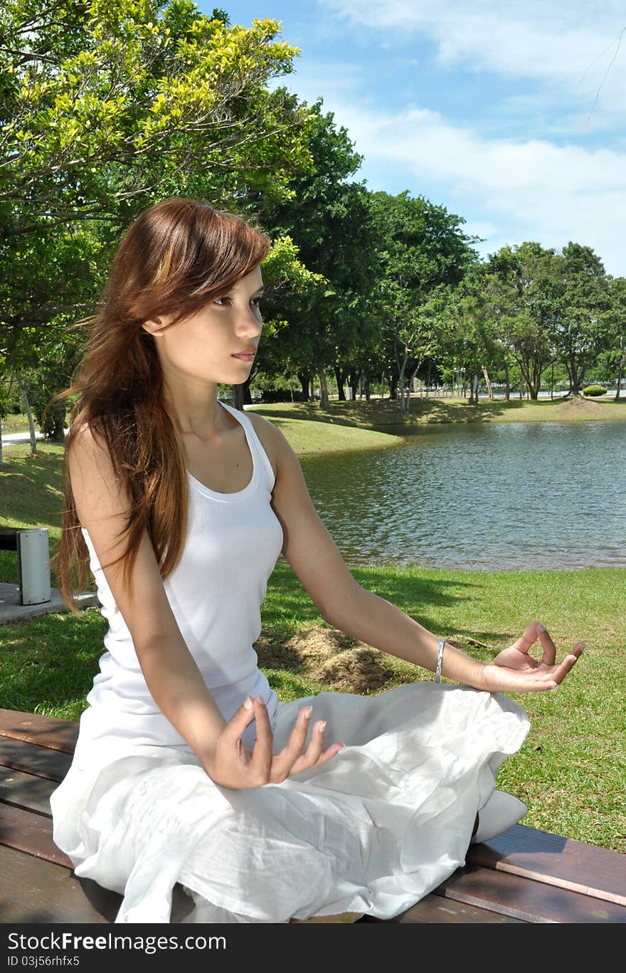 Young girl meditating in the park