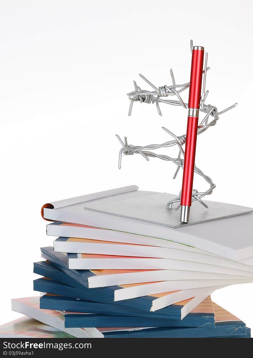 The barbed wire and a pen on note book stack on white background