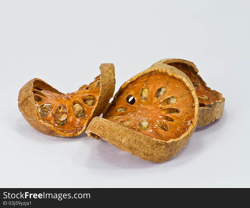 Slices of dried bael fruit on white background