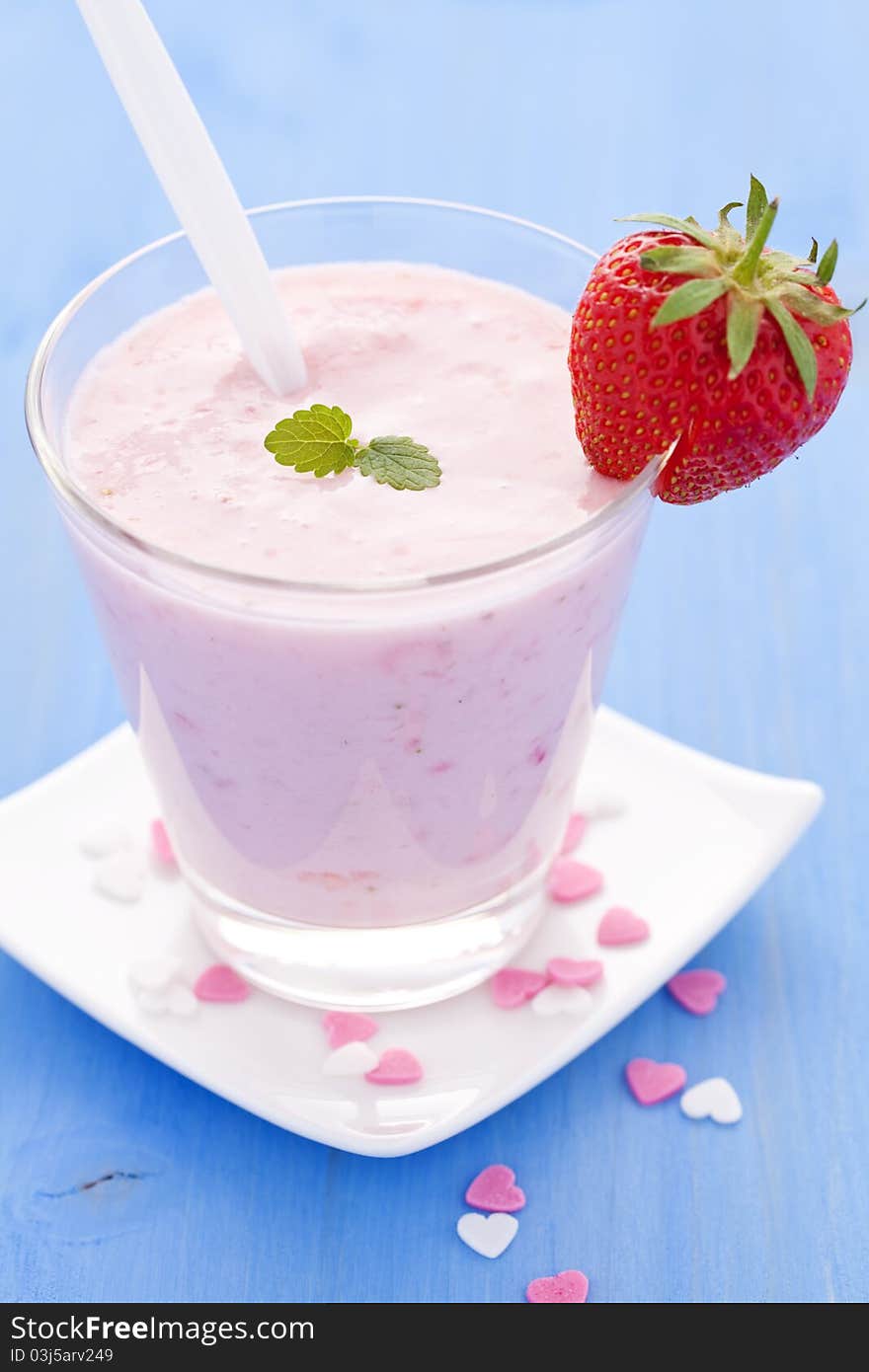 Fresh strawberry shake in a glass with spoon