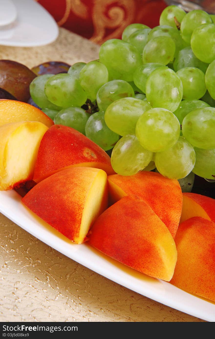 Grape and peach on white dish. Restaurant. Grape and peach on white dish. Restaurant