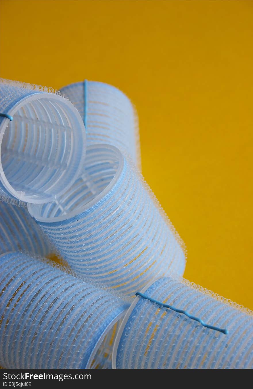 Close-up shot of the blue hair curlers on orange background.