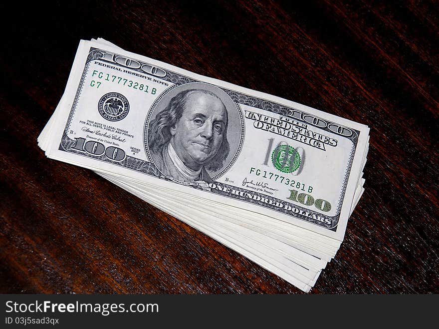 Bundle of dollar banknotes lying on a table surface. Bundle of dollar banknotes lying on a table surface