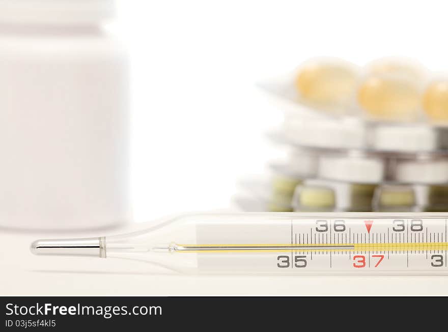 Medical still-life with thermometer and tablets. Temperature is 36.6. Medical still-life with thermometer and tablets. Temperature is 36.6.