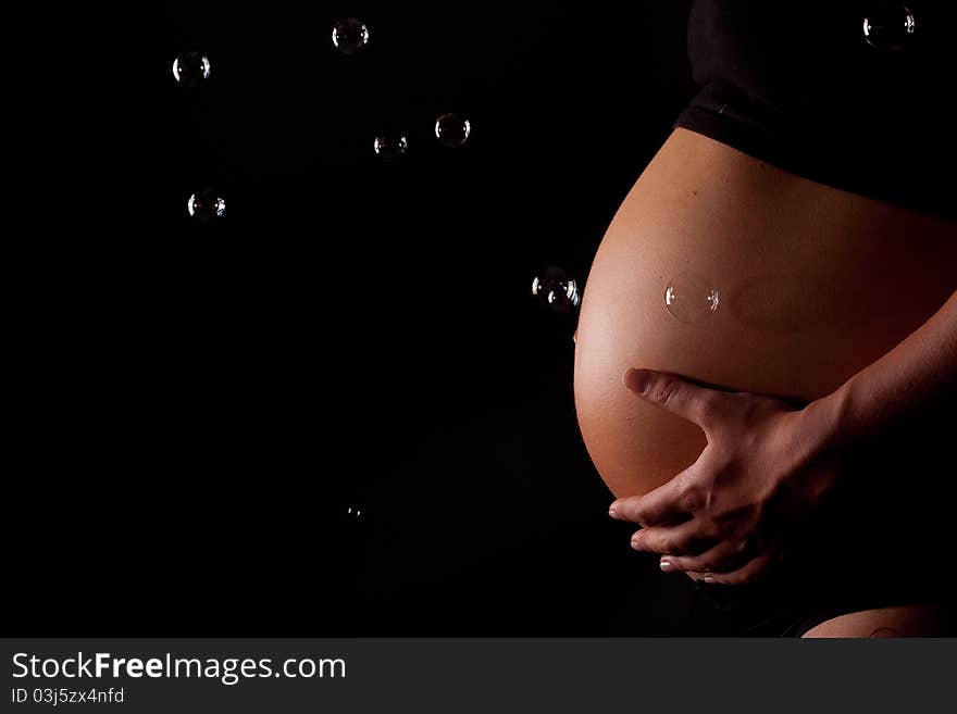 A beautifull close up of a pregnant belly with bubbles. A beautifull close up of a pregnant belly with bubbles