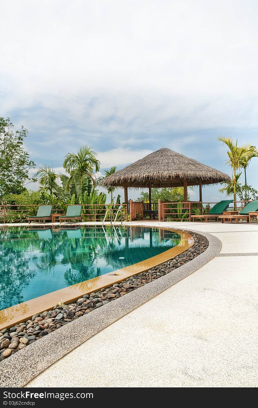 View of nice tropical pool with exotic hut on the back. View of nice tropical pool with exotic hut on the back