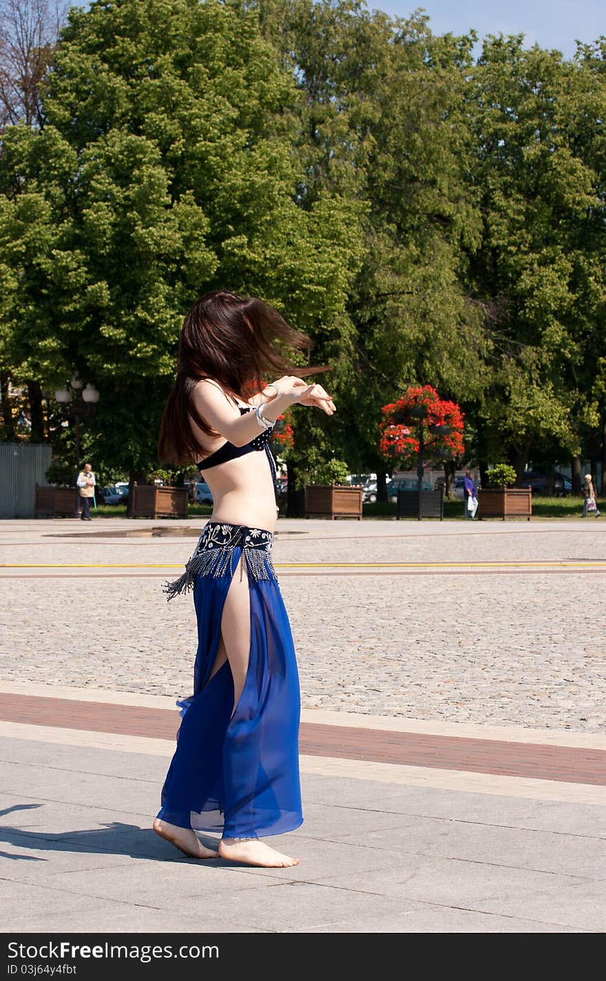 Dancing woman in city square on sunny day in summer