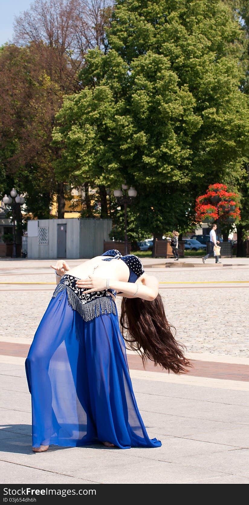 Dancing woman in city square on sunny day in summer