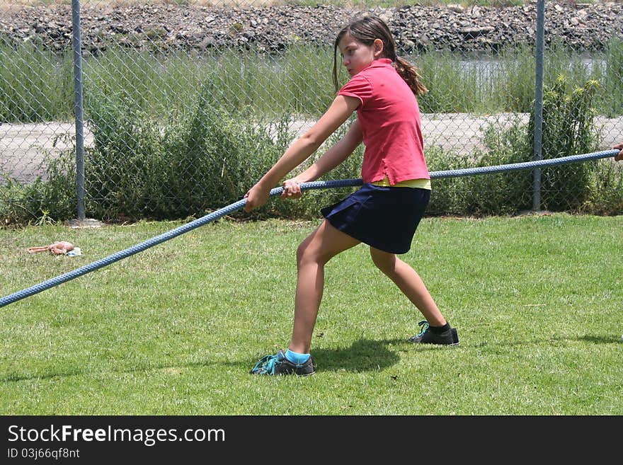 Girl pulling on a rope in a tug-o-war. Girl pulling on a rope in a tug-o-war.