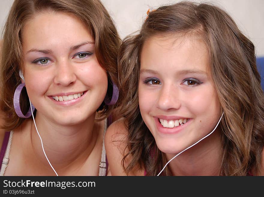 Two beautiful young women listening to their MP3 players. Two beautiful young women listening to their MP3 players