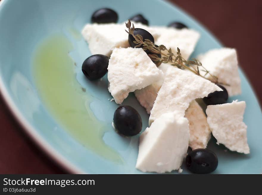 Cottage cheese and thyme twig on a plate. shallow DOFF