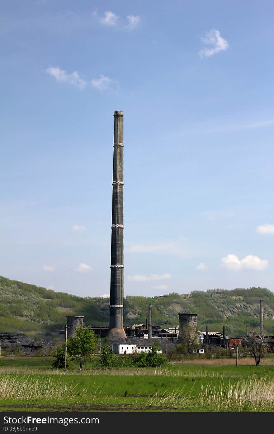 Landscape with old industrial buildings and a tower or funnel in the background. Landscape with old industrial buildings and a tower or funnel in the background.