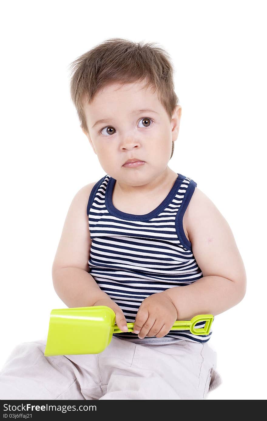 Child playing with a toy shovel on a white background. Child playing with a toy shovel on a white background