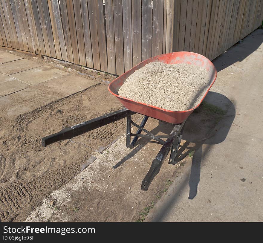 Wheelbarrow with gravel in laneway. Wheelbarrow with gravel in laneway