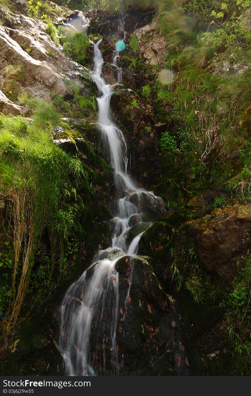 Beautiful small stream falling down rocks. Beautiful small stream falling down rocks