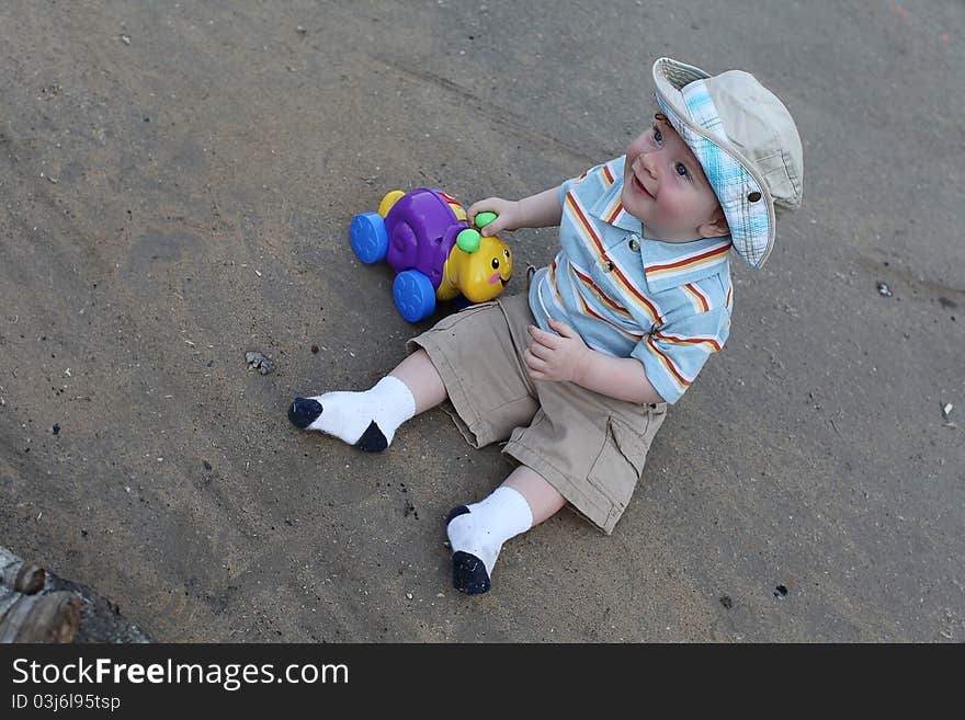 Cute little boy playing with plastic snail outdoor. Cute little boy playing with plastic snail outdoor.