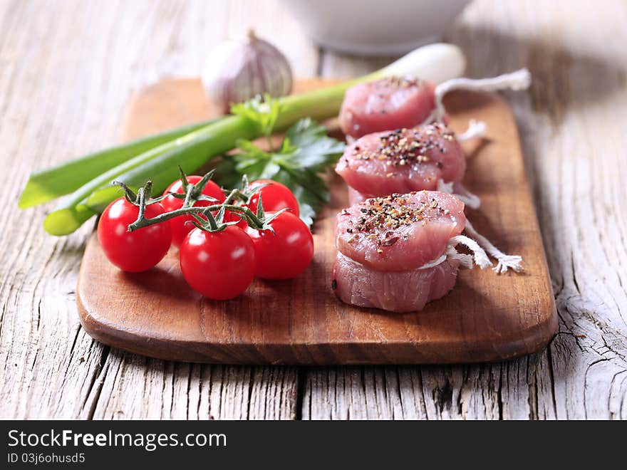 Raw pork tenderloin and vegetables