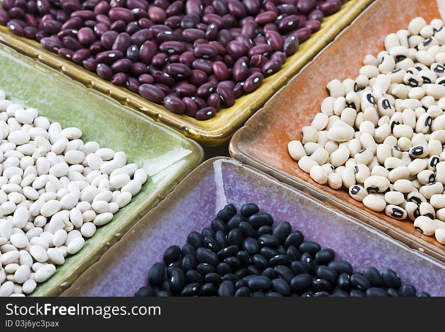 Mixed variety of dried beans in colorful square dishes. Mixed variety of dried beans in colorful square dishes