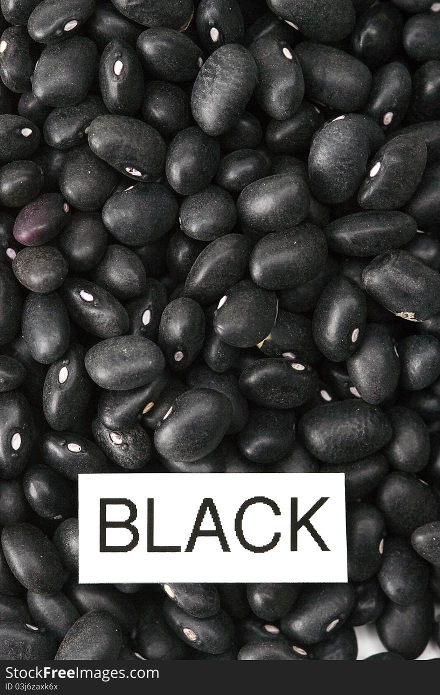 Black raw dried beans with label close-up macro background. Black raw dried beans with label close-up macro background.