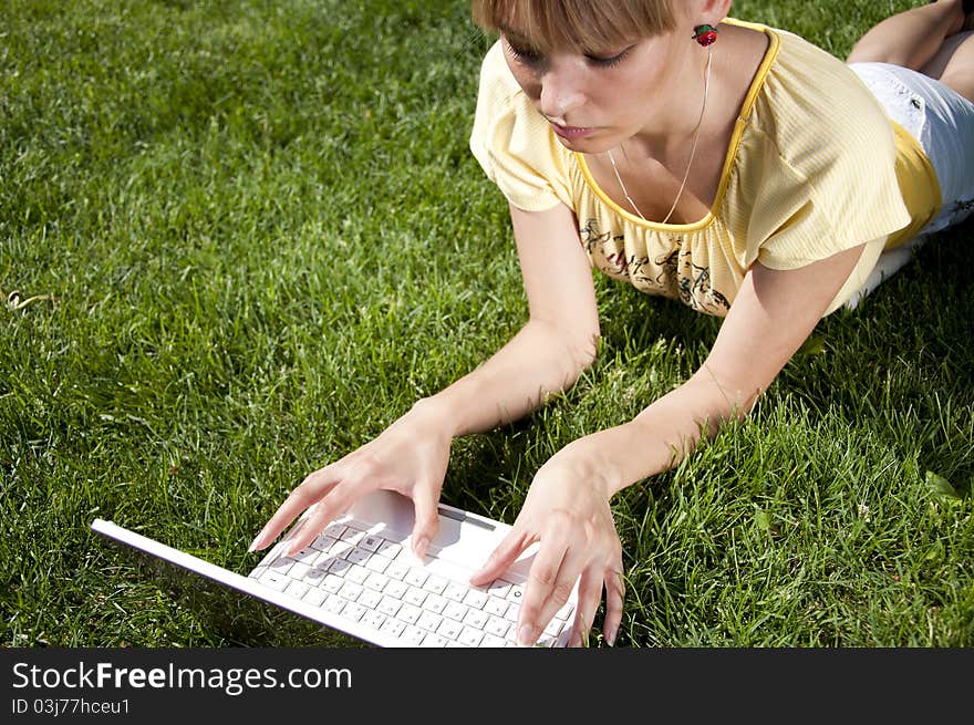 Young Woman With Laptop Sitting On Green Grass