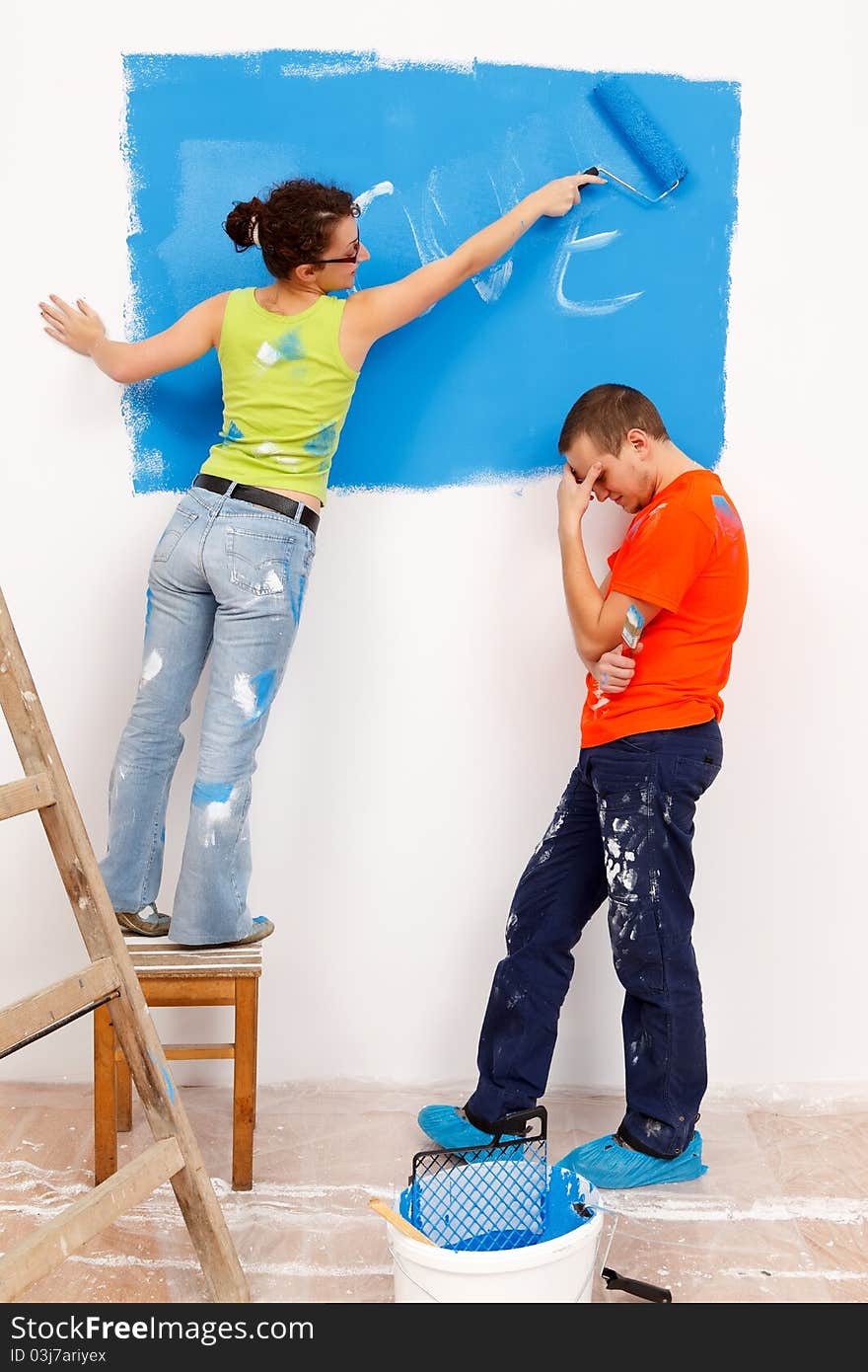 Girl repainting her love message in the wall of a renovated house. Girl repainting her love message in the wall of a renovated house