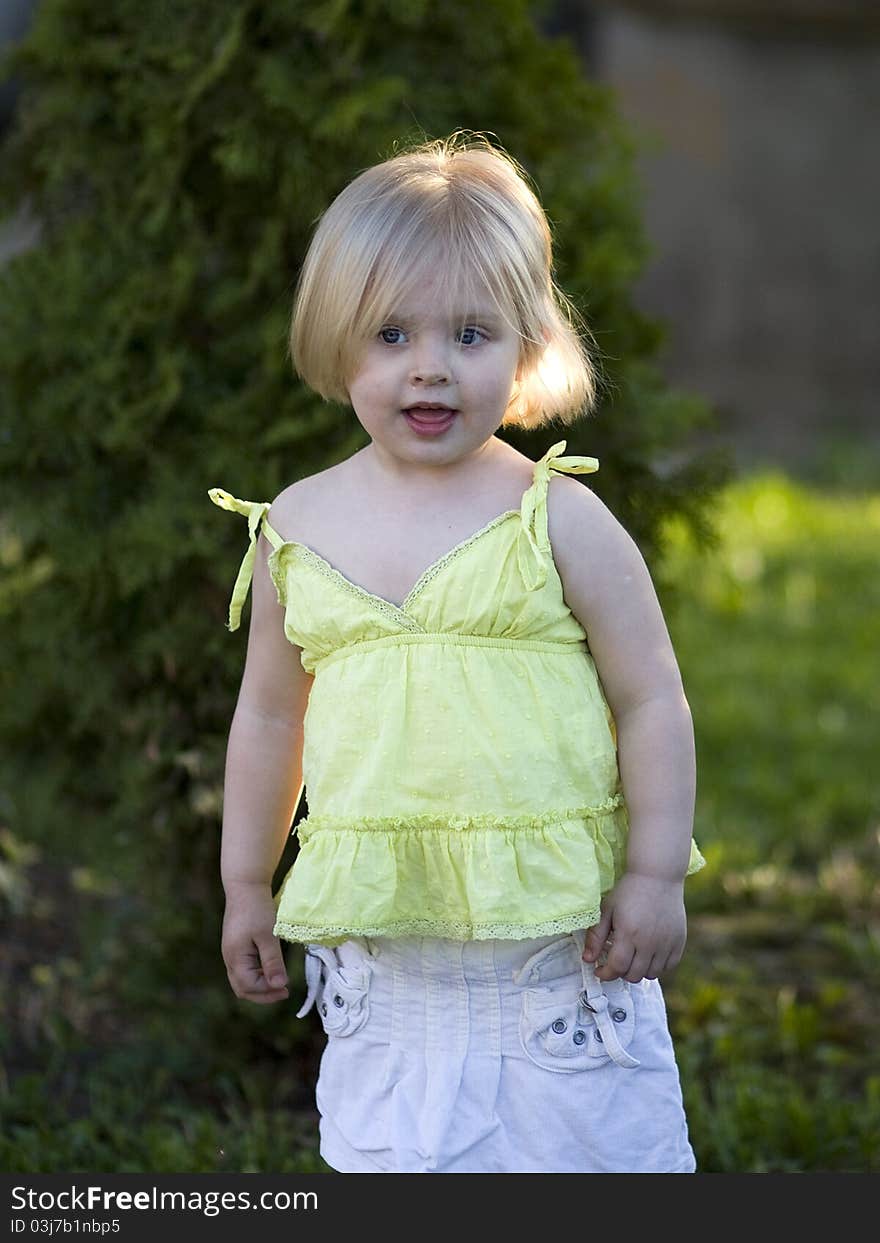 A portrait of a little girl standing outside