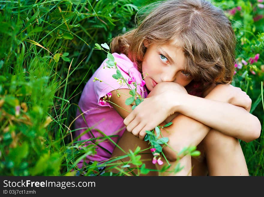 Little girl in the field with flowers