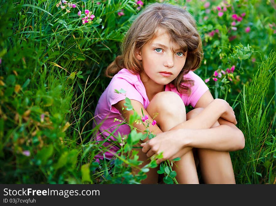 Little girl in the field with flowers