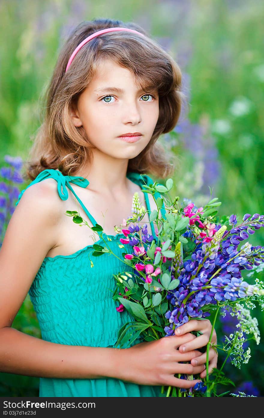 Little girl in the field with flowers