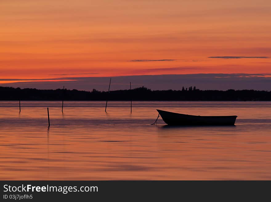 Scenic view of small fishing boat at sunset with cloudscape background. Scenic view of small fishing boat at sunset with cloudscape background.