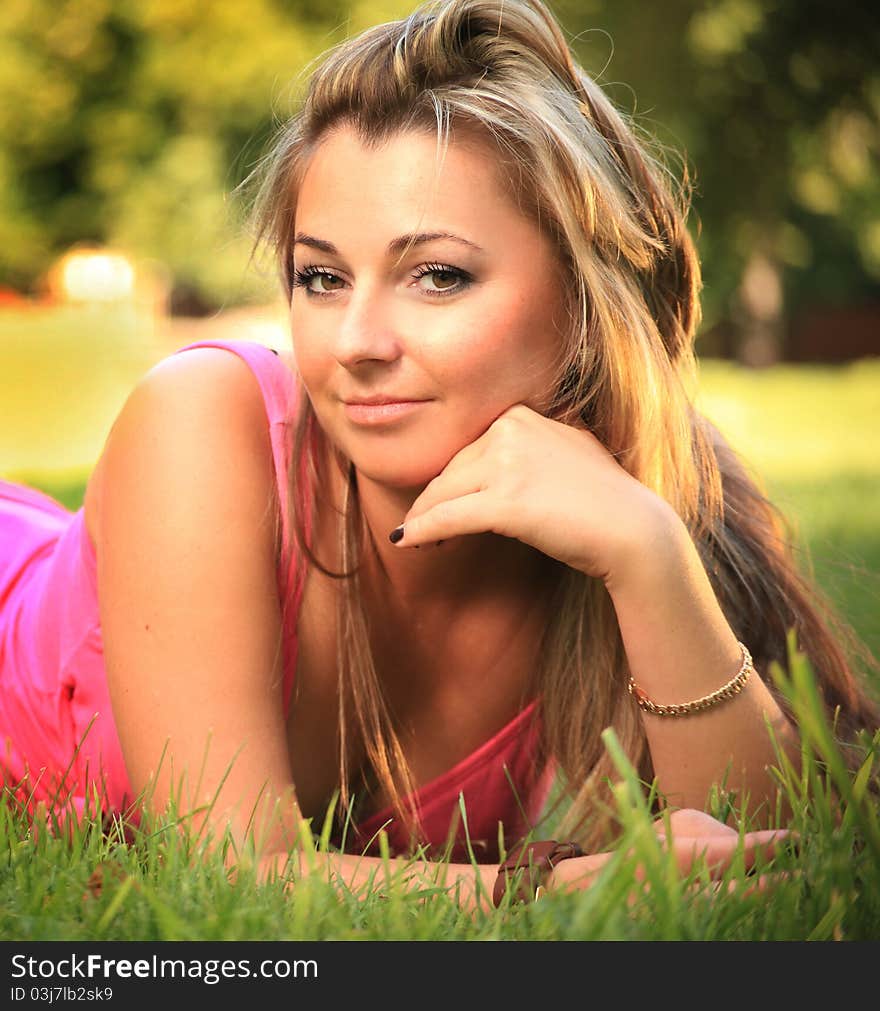 Beautiful young woman relaxing on a grass. Beautiful young woman relaxing on a grass