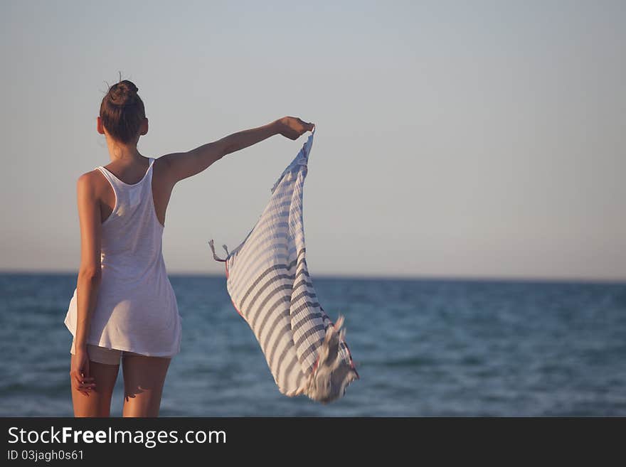 Woman holding scarf at the beach