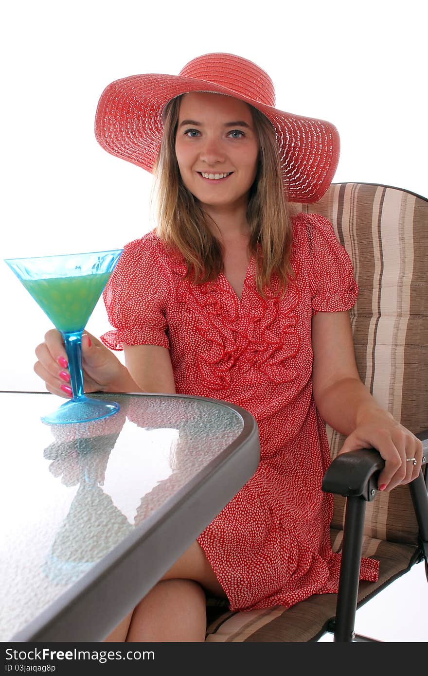 Woman sitting on a patio with a drink in hand. Woman sitting on a patio with a drink in hand
