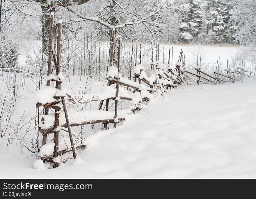 Wooden fence covered with snow. Wooden fence covered with snow.