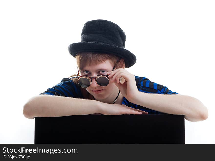 Young woman in black hat looking suspiciously over sunglasses isolated. Young woman in black hat looking suspiciously over sunglasses isolated