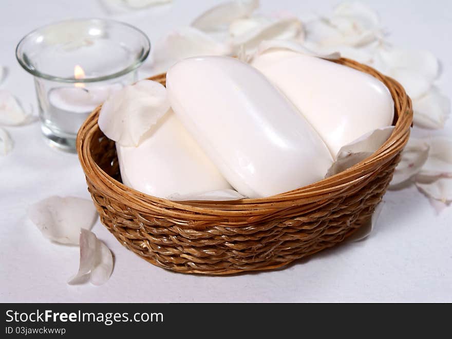 White soaps in basket with candle