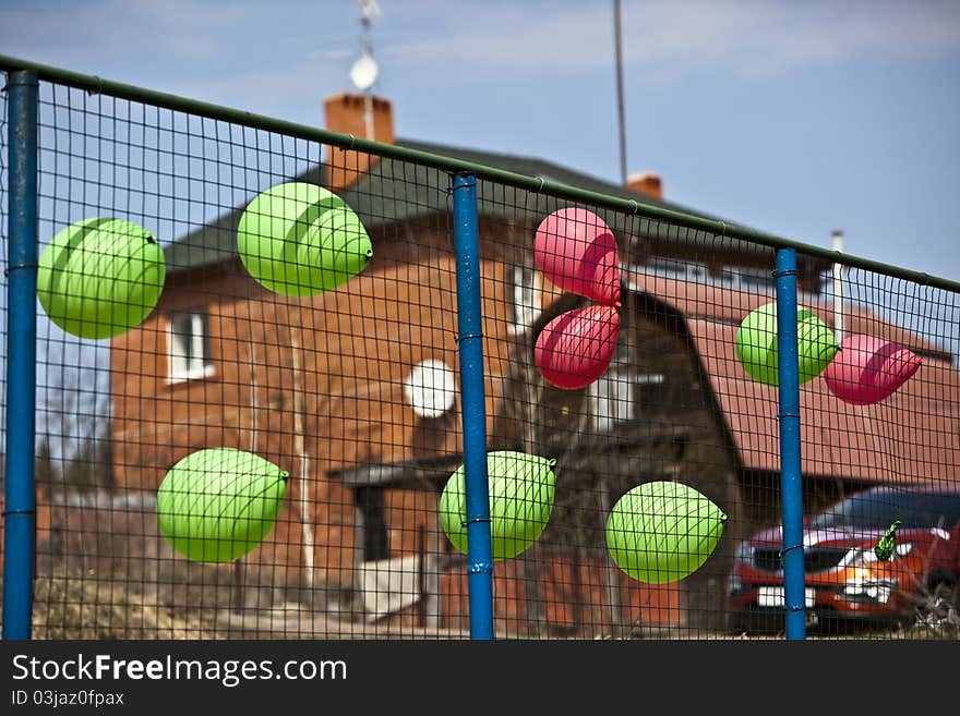 Multi-colored balloons on a fence