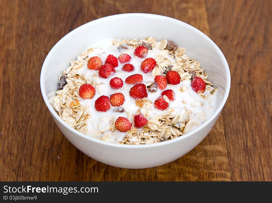 Bowl of muesli with yogurt and wild strawberry. Bowl of muesli with yogurt and wild strawberry