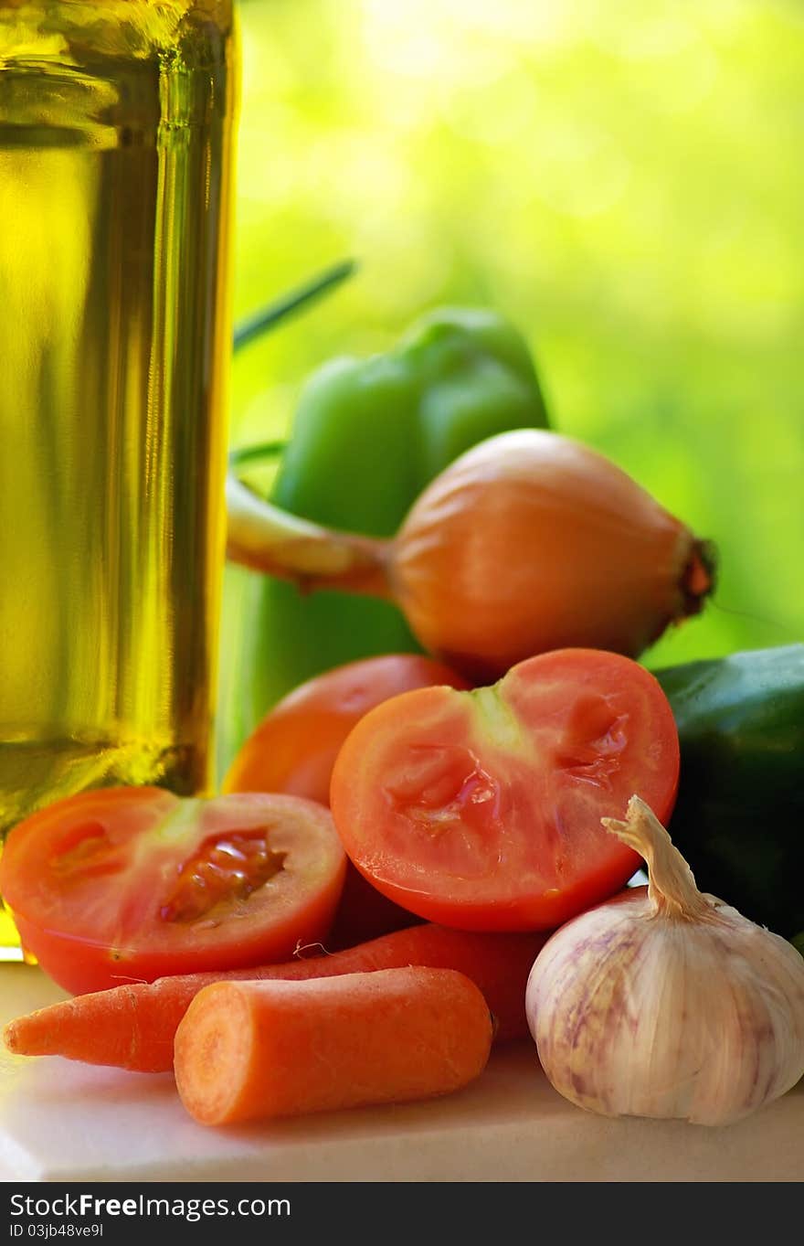 Olive oil and vegetables in green background. Olive oil and vegetables in green background.