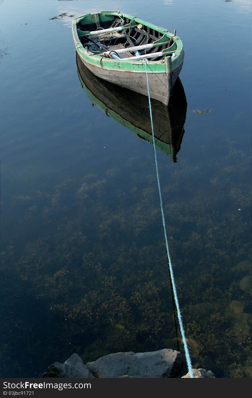 Small rowboat on a lake tied to the shore