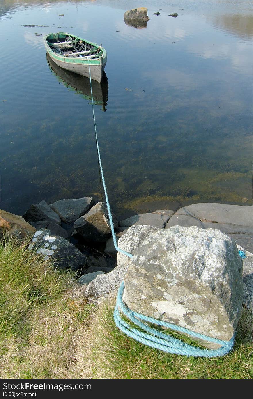 Small rowboat on a lake tied to the shore