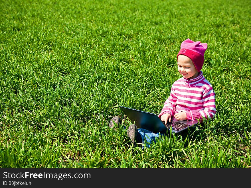 Little girl sitting with a laptop