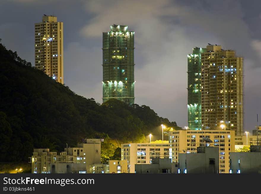 Hong Kong Night Sky with Sparkling Tungsten Lighting Coming Out from Buildings adjacent to Hillside. Hong Kong Night Sky with Sparkling Tungsten Lighting Coming Out from Buildings adjacent to Hillside