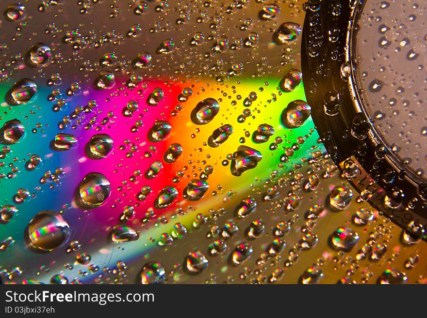 Images drops of water on the CD reflect rainbow colors. Images drops of water on the CD reflect rainbow colors.