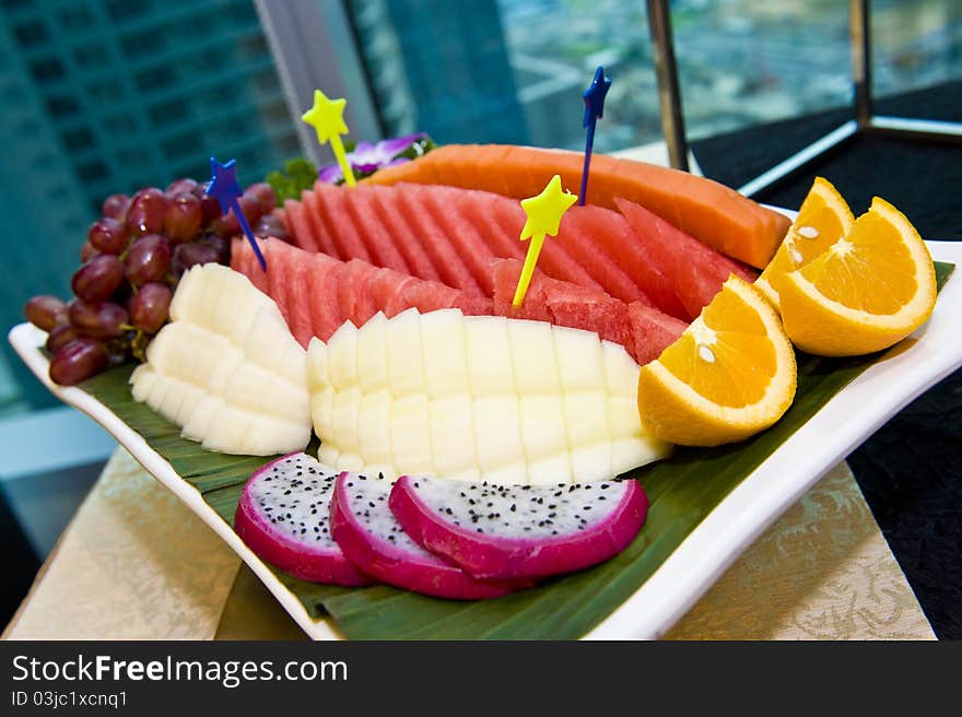 A plate of nicely sliced and decorated fruits ready to be served. A plate of nicely sliced and decorated fruits ready to be served.