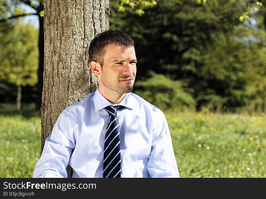 Young businessman alone in nature in summer. Young businessman alone in nature in summer